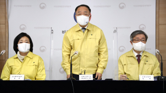 홍남기 부총리 겸 기획재정부 장관이 29일 정부서울청사에서 '코로나19 3차 확산에 대응한 맞춤형 피해지원 대책'을 발표하고 있다. 왼쪽부터 박영선 중소벤처기업부 장관, 홍남기 부총리, 이재갑 고용노동부 장관. 연합뉴스.